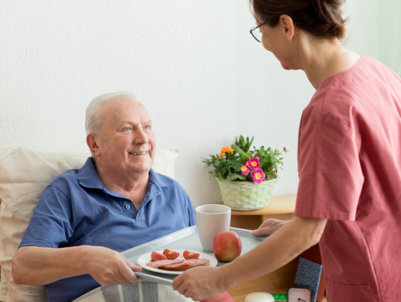 Caregiver bringing a fresh meal to a resident